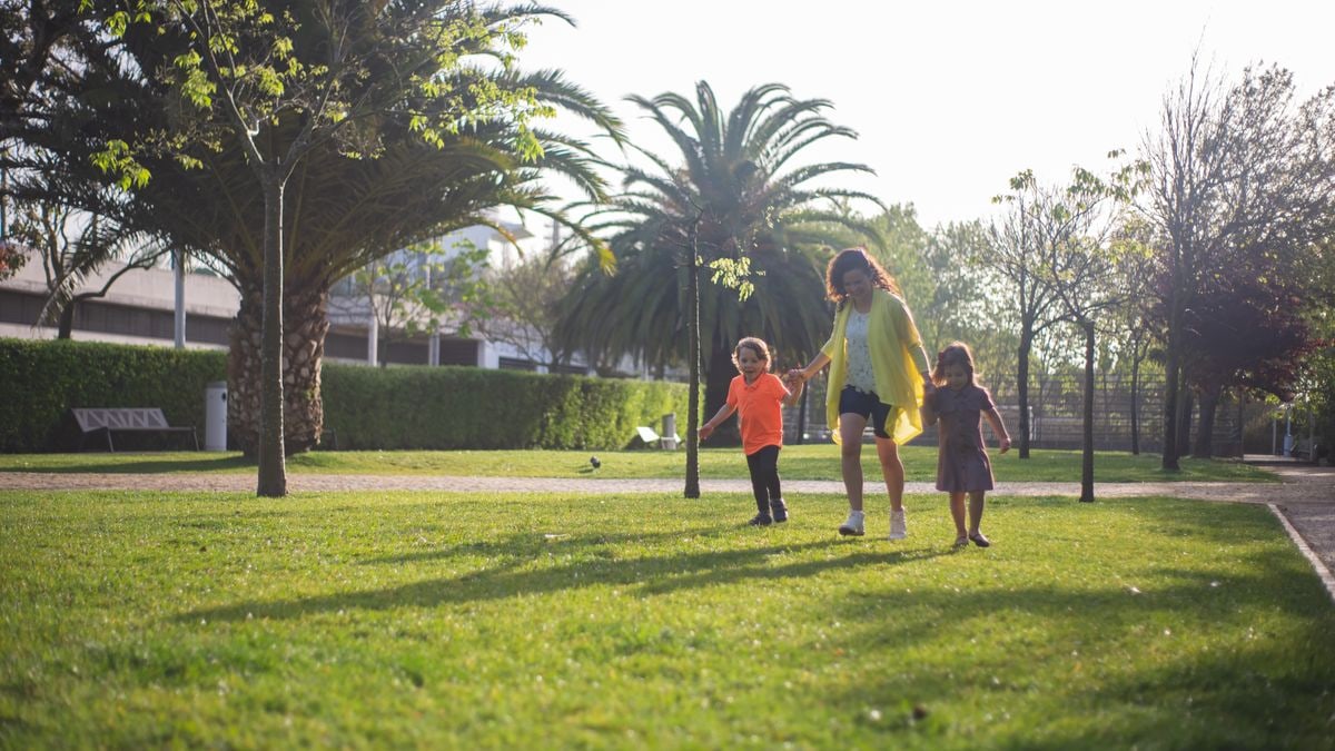 A joyful family enjoys a sunny day walking in a lush green park in Portugal.